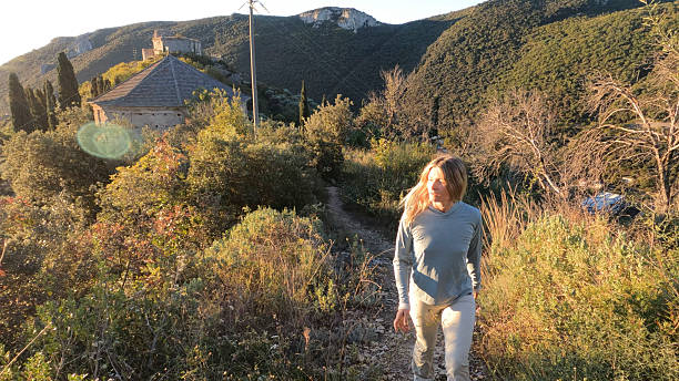 Young woman walks in forest at sunrise, Liguria