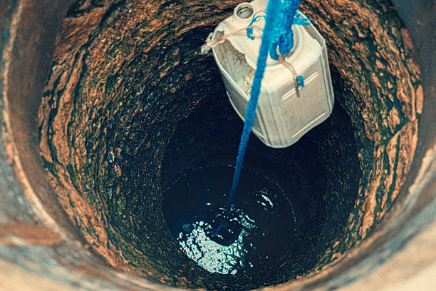 istock Plastic Jerrycan Lowered into an Old Stone Well to Collect Water. 2247671094