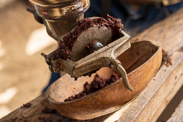 Vintage manual coffee grinder to grind fresh roasted beans into a older bowl.