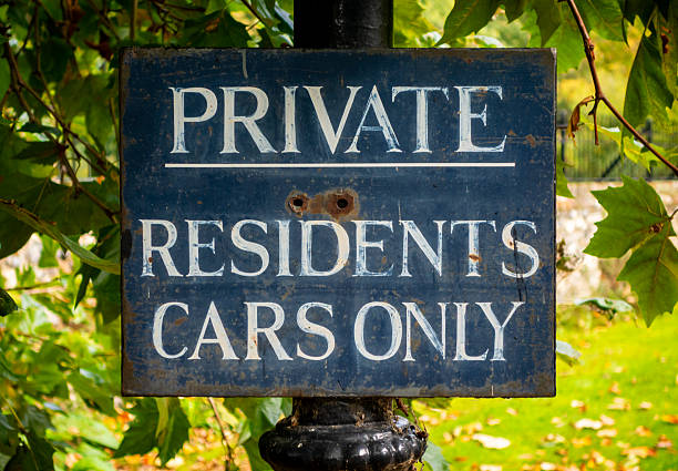 A rather weathered and rusty sign with hand lettering announcing “Private - Residents Cars Only” in the Cathedral Close near the Cathedral in Norwich, Norfolk, Eastern England.
