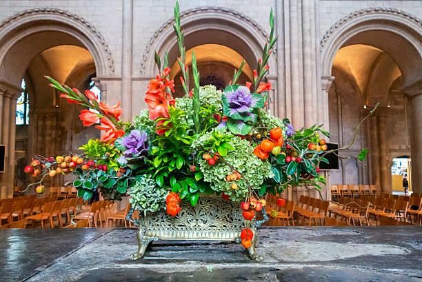 Beautifully arranged autumn flowers standing on the top of a tomb in the 11th century Norwich Cathedral in Norwich, Norfolk, eastern England.