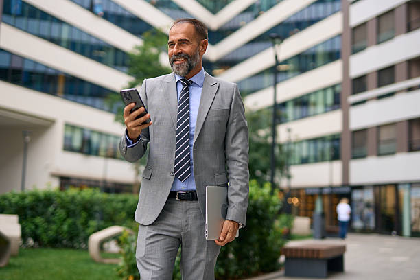 istock Confident businessman connecting using smartphone and laptop outdoors 2247675984