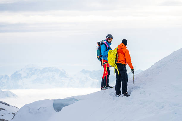 istock Climbers on a Snowy Mountain Peak with Ice Axes and Backpacks 2247676911