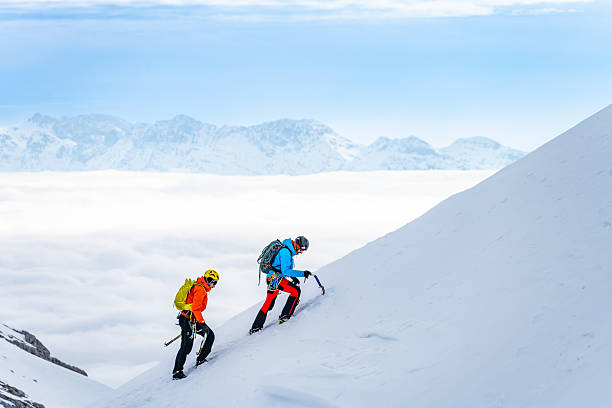 istock Two Climbers Ascend Snowy Mountain Slope with Backpacks and Ice Axes 2247676941