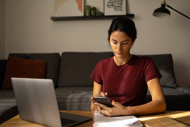 istock Woman working from home using smartphone and laptop 2247677096