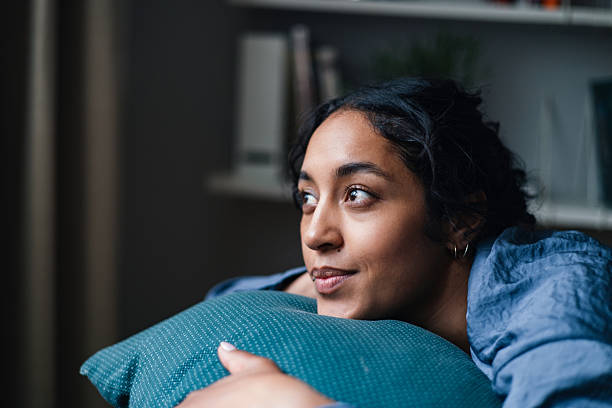 istock Contemplative Woman Resting At Home With A Teal Pillow In Soft Natural Light 2247678808