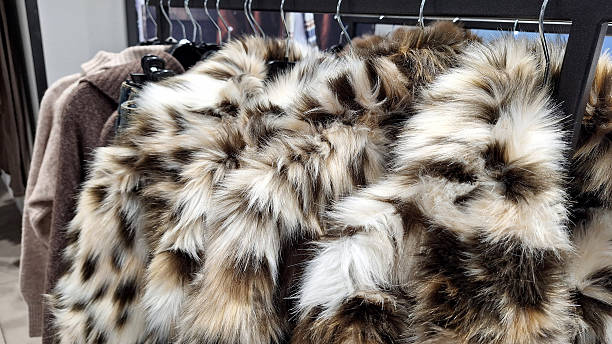 istock Faux fur coats on hangers in clothing store display 2247681993
