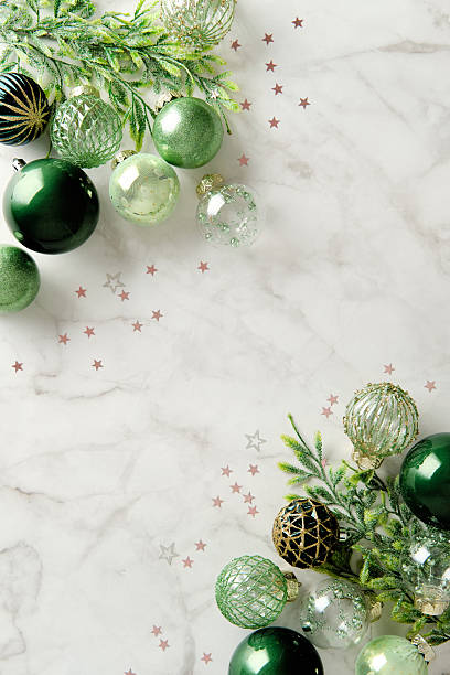 istock Vertical Christmas background with green balls and spruce branches on marble table 2247682414