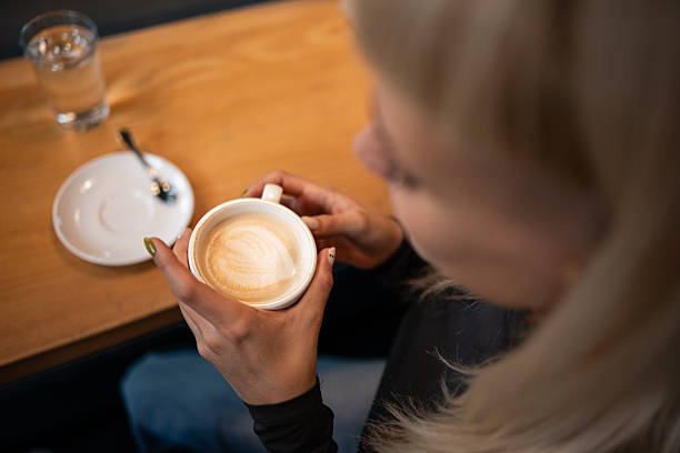 istock Woman holding coffee cup relaxing in cafe 2247682551