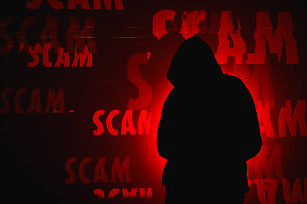 istock Hooded figure standing in front of red glitching scam text 2247682631