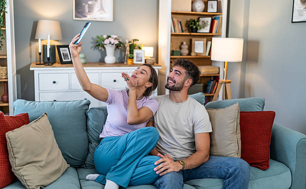 istock Young couple taking selfie blowing kiss at home 2247684927