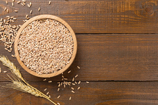 istock Bowl with spelt grain on wooden background, top view 2247685244