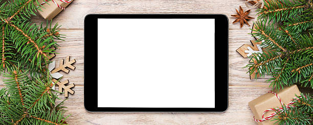 istock Digital tablet mock up with rustic Christmas wood background decorations for app presentation. top view with copy space 2247685903