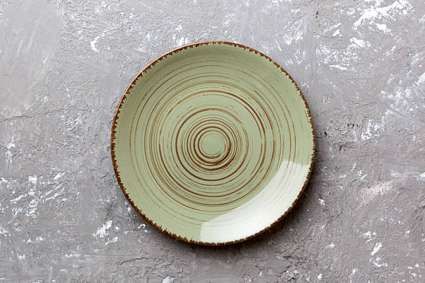 istock Top view of empty green plate on cement background. Empty space for your design 2247685940