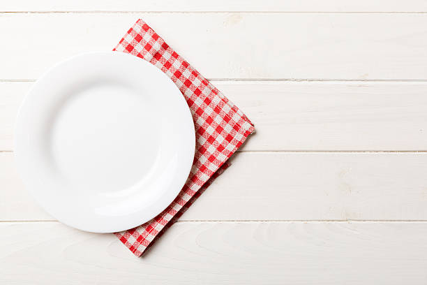 istock Top view on colored background empty round white plate on tablecloth for food. Empty dish on napkin with space for your design 2247685952