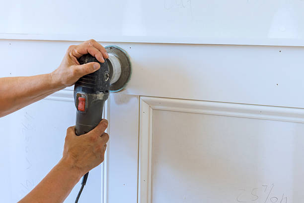 istock Hand using sander to smooth wood paneling in home renovation 2247686089