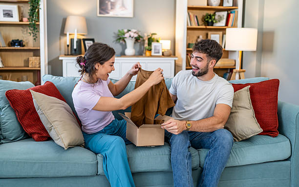 istock Young couple unboxing online purchase at home laughing 2247686262