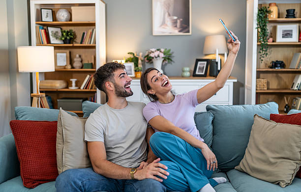 istock Young couple taking happy selfie at home 2247686404