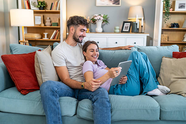 istock Young couple relaxing at home watching digital tablet 2247686418