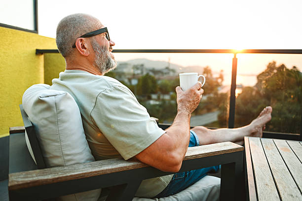 istock mature adult man relaxing on the balcony and drinking tea 2247686892
