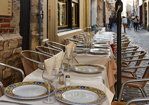 Outdoor dining setup with elegantly arranged tables and chairs, showcasing a charming street scene and inviting atmosphere for patrons