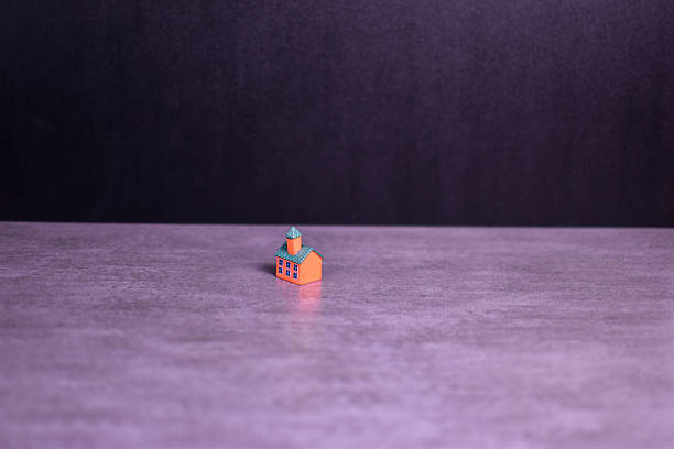 Brightly colored model building on dark background emphasizes architectural detail, isolation, and visual contrast in a minimalistic composition.