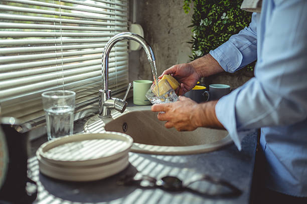 istock Man washing glass and sponge in kitchen sink 2247692960