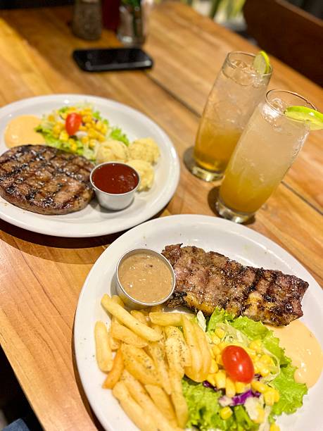 Delicious steak and fries dinner with refreshing drinks at cozy restaurant, showcasing culinary excellence and inviting atmosphere for a memorable experience