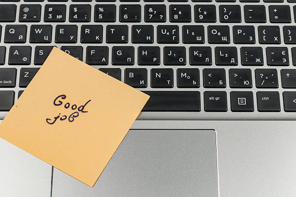 istock Sticky note with good job message on laptop keyboard during work hours 2247695767
