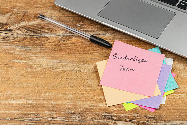 istock Notes and a laptop on a wooden desk during a team collaboration session 2247695810