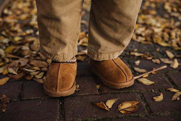 istock Child wearing warm slippers walking on fall leaves 2247696428