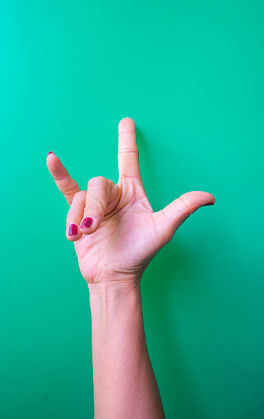 istock Female hand showing peace sign on a green background with copyspace 2247709997