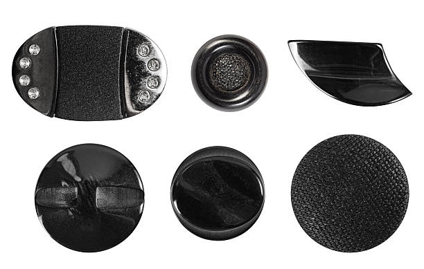 Isolated photo of various black plastic cloth decorative cloth buttons or rivets on white background.