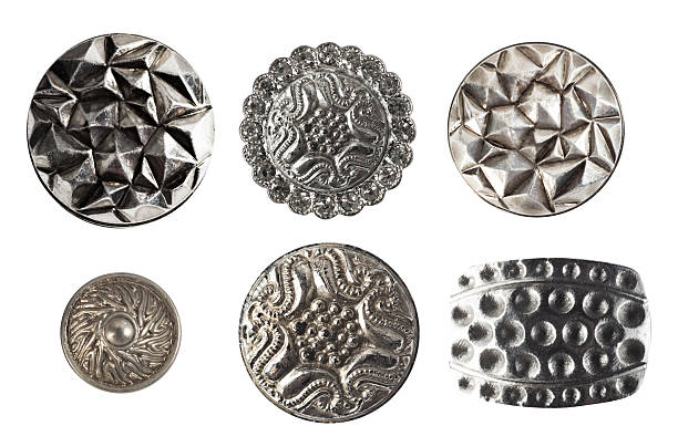 Isolated photo of various steel metal silver decorative cloth buttons, rivets and earrings on white background.
