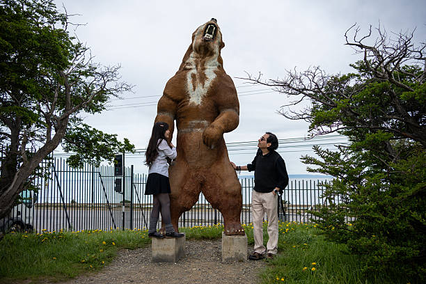 Father and Daughter Posing with a Giant Standing Bear Statue
