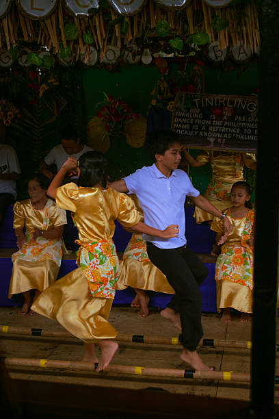 August 21, 2025. Bohol, Philippines. A lively cultural presentation of the traditional Filipino Tinikling dance performed aboard the Loboc River Cruise in Bohol, Philippines. Dancers in vibrant attire gracefully step between bamboo poles to the rhythm of live native music, showcasing the rich heritage and artistry of Filipino folk dance.
