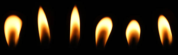 istock A candle flame is burning at night in close range, yellow light isolated on a black background. Concept for taking graphics for birthdays, Halloween, and Christmas. glow wick 2247720165