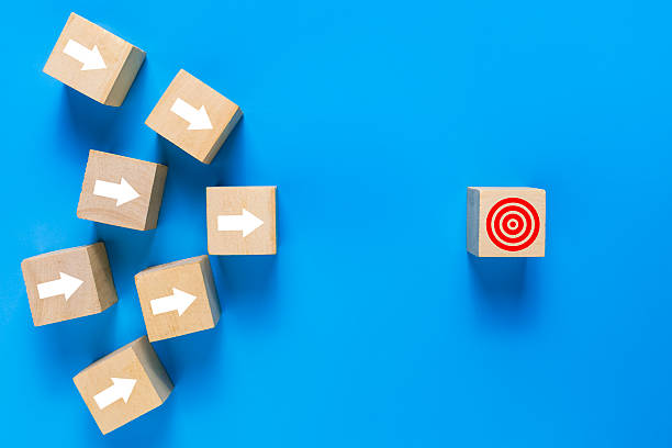 istock wooden blocks with white arrow pointing on target isolated on blue background. concept of goals achievement 2247730032