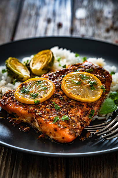 istock Baked salmon with white rice on wooden table 2247730327