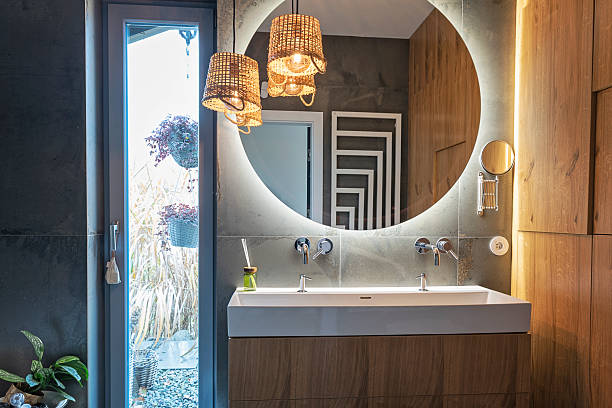 istock Interior decor of bathroom with ceramic wash basin with round mirror with LED light and dark tile on the wall. Elegance and luxury at home interior. Spa. 2247730397