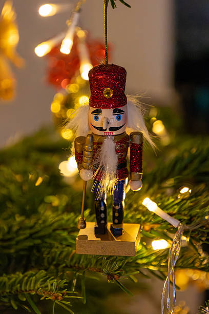 istock Festive decoration: Classic nutcracker figure with red, glittery hat and white beard in a Christmas tree 2247732321