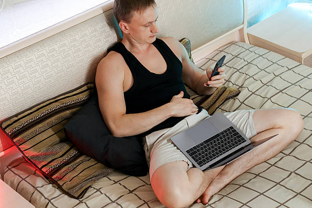 istock Man leaning back with phone and laptop in relaxed pose 2247732947