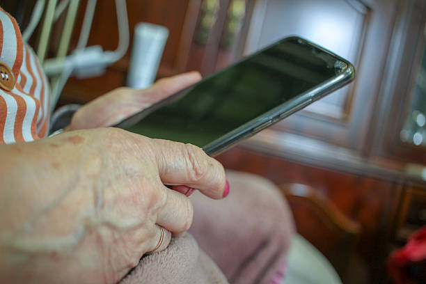 istock Tranquil scene of older hands with mobile phone 2247738750