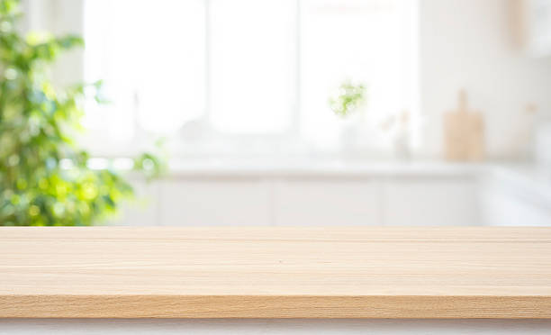 istock Wooden table top for product display with deeply blurred modern kitchen interior background 2247738799