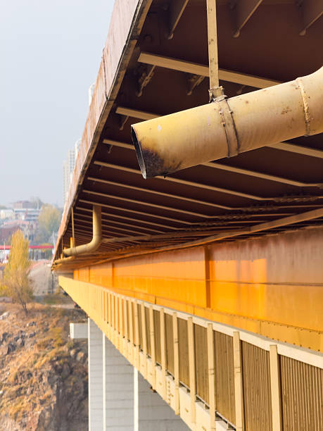 istock Old bridge side view from below, pedestrian passage under the bridge, water drain from the bridge, rainwater drainage pipe 2247738924