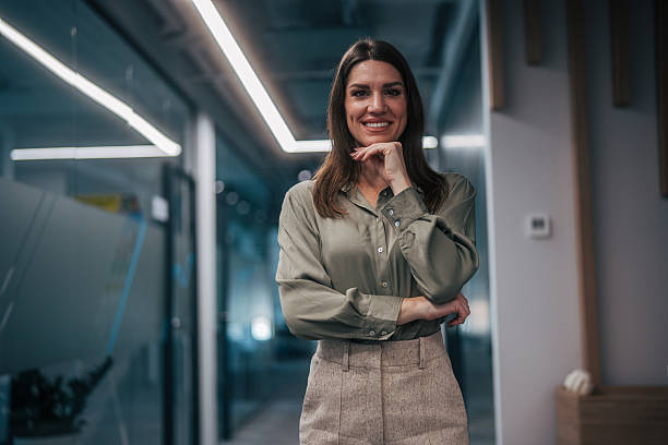 istock Confident businesswoman smiling in modern office hallway 2247741804
