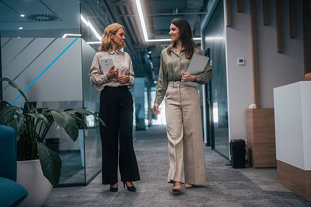 istock Businesswomen walking office corridor having conversation 2247743840