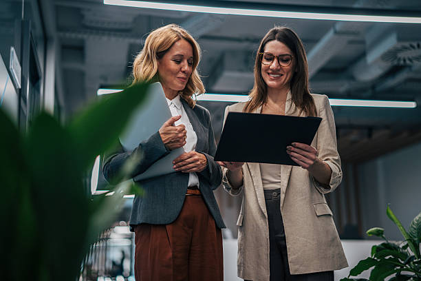 istock Businesswomen walking and collaborating in modern office hallway 2247744122