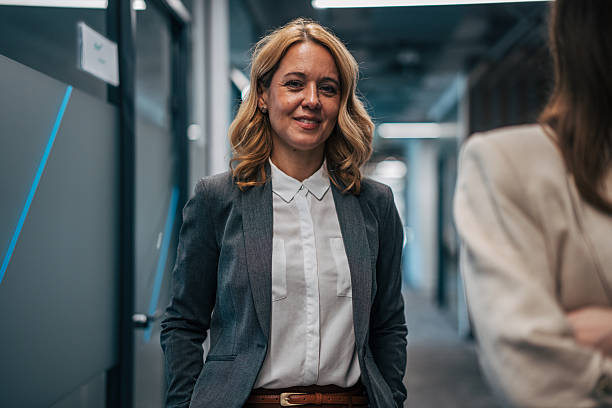 istock Smiling businesswoman standing confidently in modern office hallway 2247744229