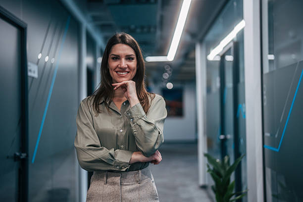 istock Businesswoman smiling standing in modern office corridor 2247744509